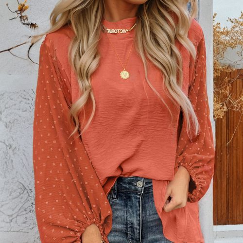 Russet-oranje blouse met Zwitserse stippen en ballonmouwen, losvallend model.