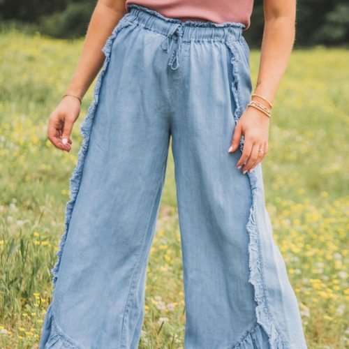 Calça jeans Myosotis de lavagem clara, barra desfiada e pernas largas com babados.